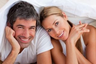 smiling couple in bed