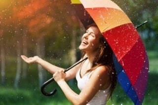 woman with umbrella laughing at the rain
