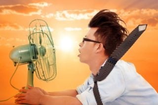 photo of hot man trying to get cool in front of fan