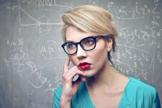 woman in front of blackboard covered with equations