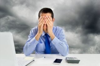 depiction of stressed man sitting at his work desk