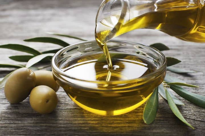 olive oil being poured into a bowl