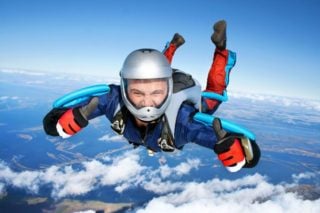 man giving thumbs up while skydiving