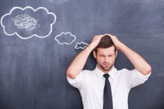 photo depicting stressed man holding head