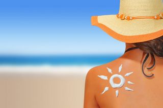 woman in hat sitting on the beach