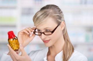 woman looking at a bottle of pills