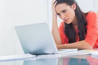 unhappy woman using laptop