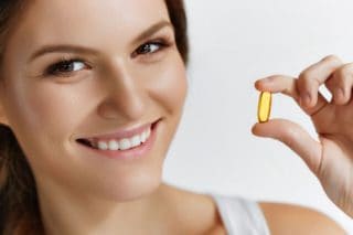 woman holding supplement capsule