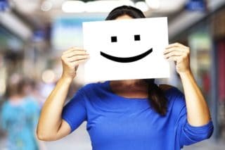 woman holding smile card in front of her face