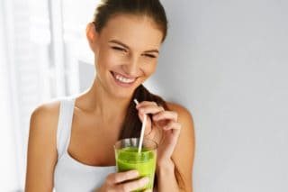 woman drinking green smoothie