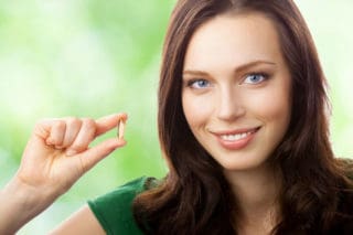 woman holding supplement capsule