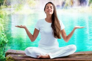 woman meditating by pond