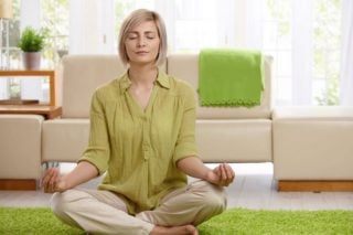 woman sitting meditating on the floor