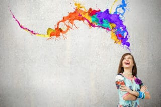 woman laughing at colorful paint swirls