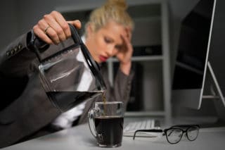 tired woman pouring cup of coffee