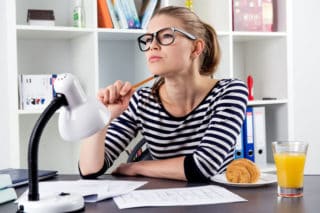 woman sitting at her desk thinking