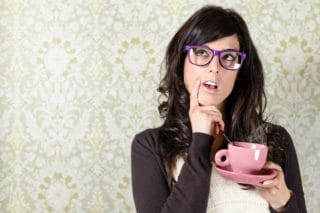 woman holding coffee cup, thinking