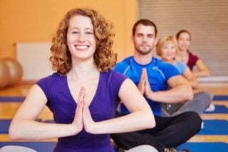 smiling woman in seated pose in yoga class